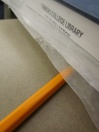 Using wax paper to protect the book, smush the glued pages in the book to solidify the spine.
